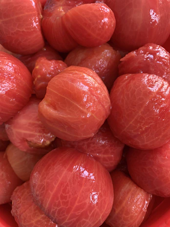 A close-up of a state-of-the-art tomato processing machine in action, with ripe tomatoes being efficiently peeled and pulped.