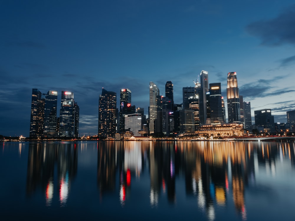 city skyline across body of water during night time