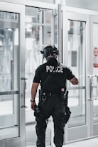 man in black helmet and black helmet standing near glass window