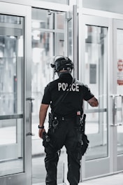 man in black helmet and black helmet standing near glass window