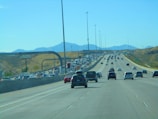 A busy highway filled with trucks moving under a clear blue sky.