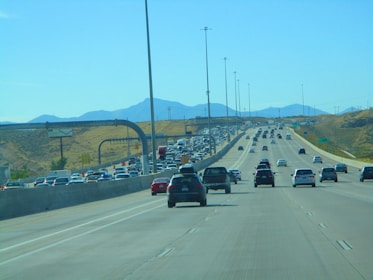 A busy highway with modern vehicles in motion under a clear blue sky.