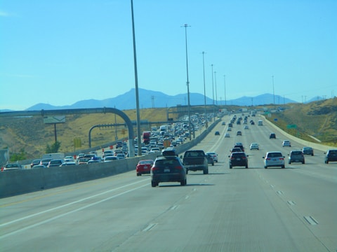 A busy highway filled with trucks moving under a clear blue sky.