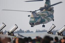 green and white helicopter flying during daytime
