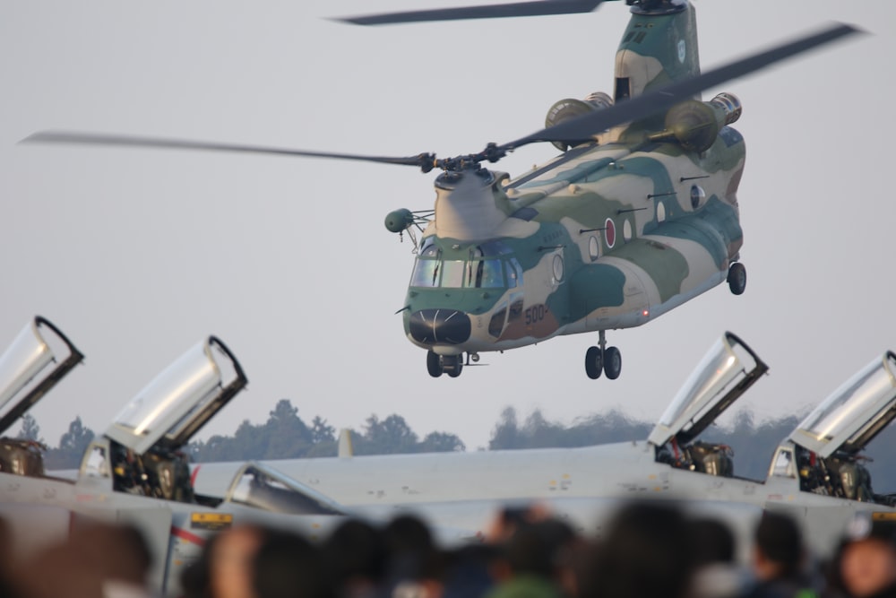 green and white helicopter flying during daytime