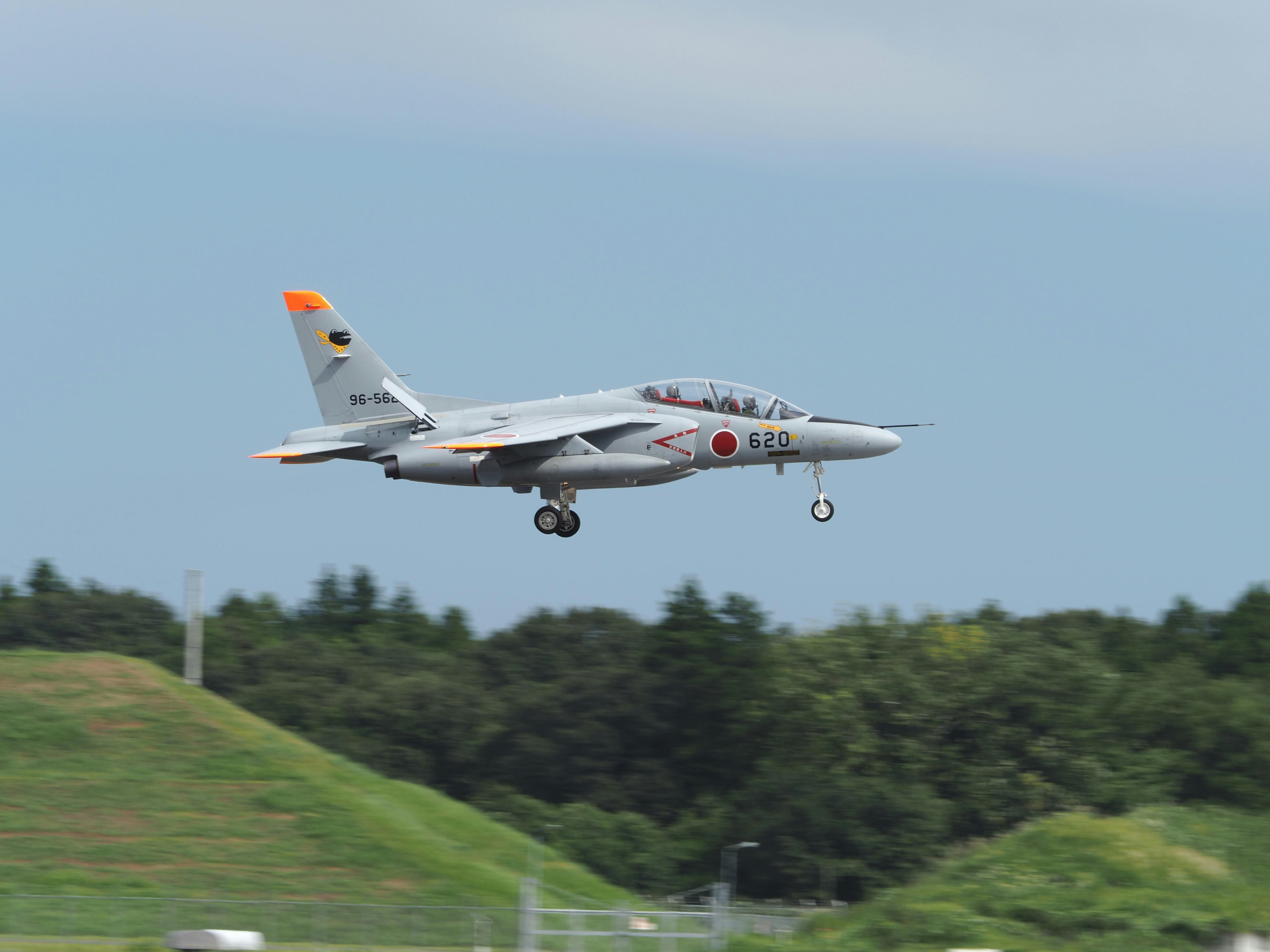 white and red jet plane flying over green grass field during daytime