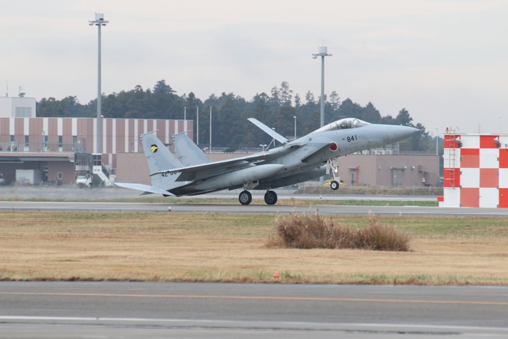 white fighter plane on brown field during daytime