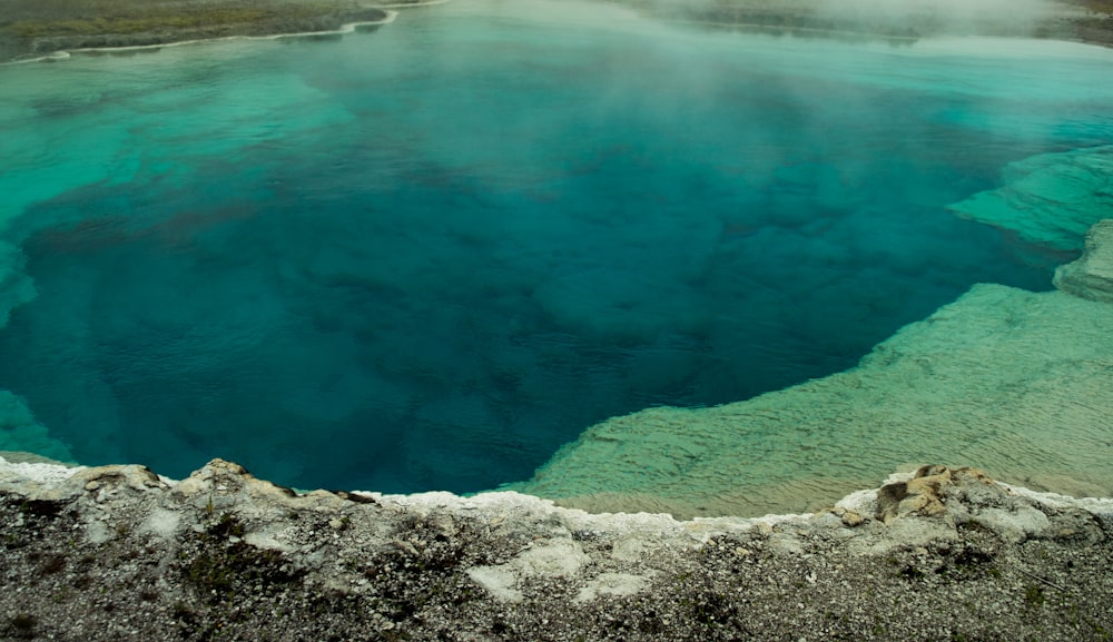 blue water and gray rocky shore during daytime