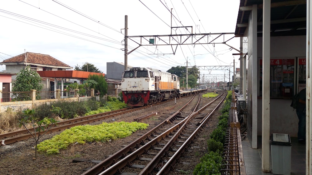 red and yellow train on rail tracks during daytime