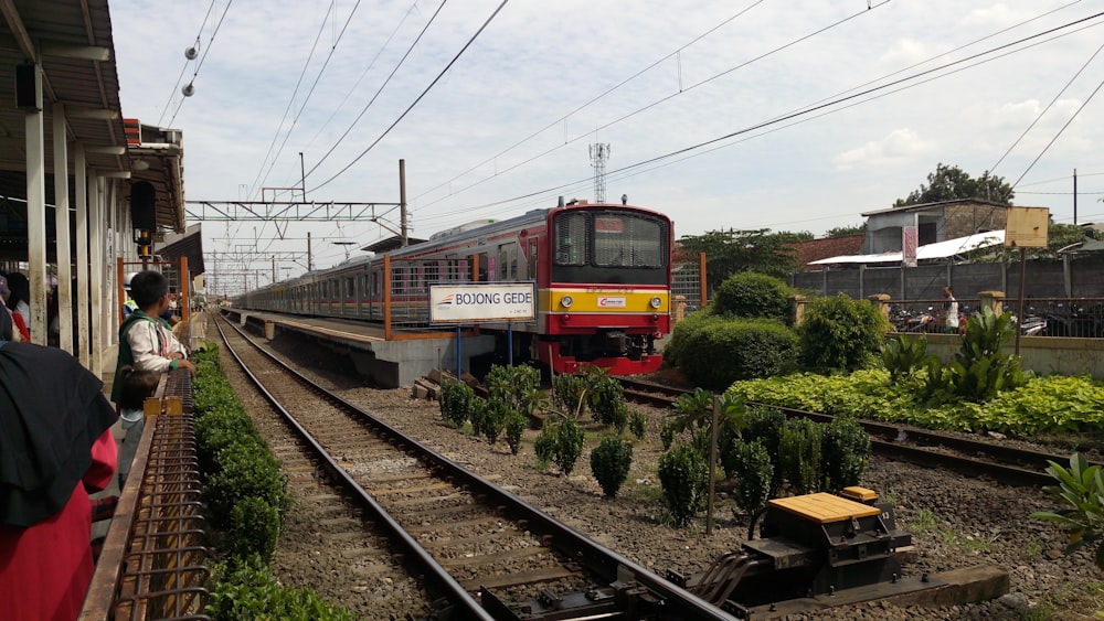 roter und gelber Zug tagsüber auf Bahngleisen