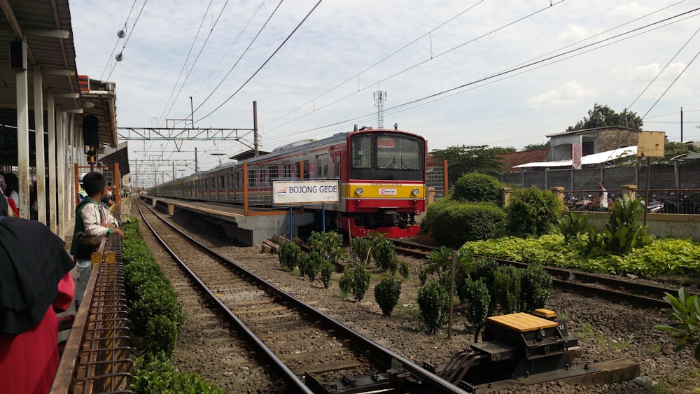 昼間の線路を走る赤と黄色の列車