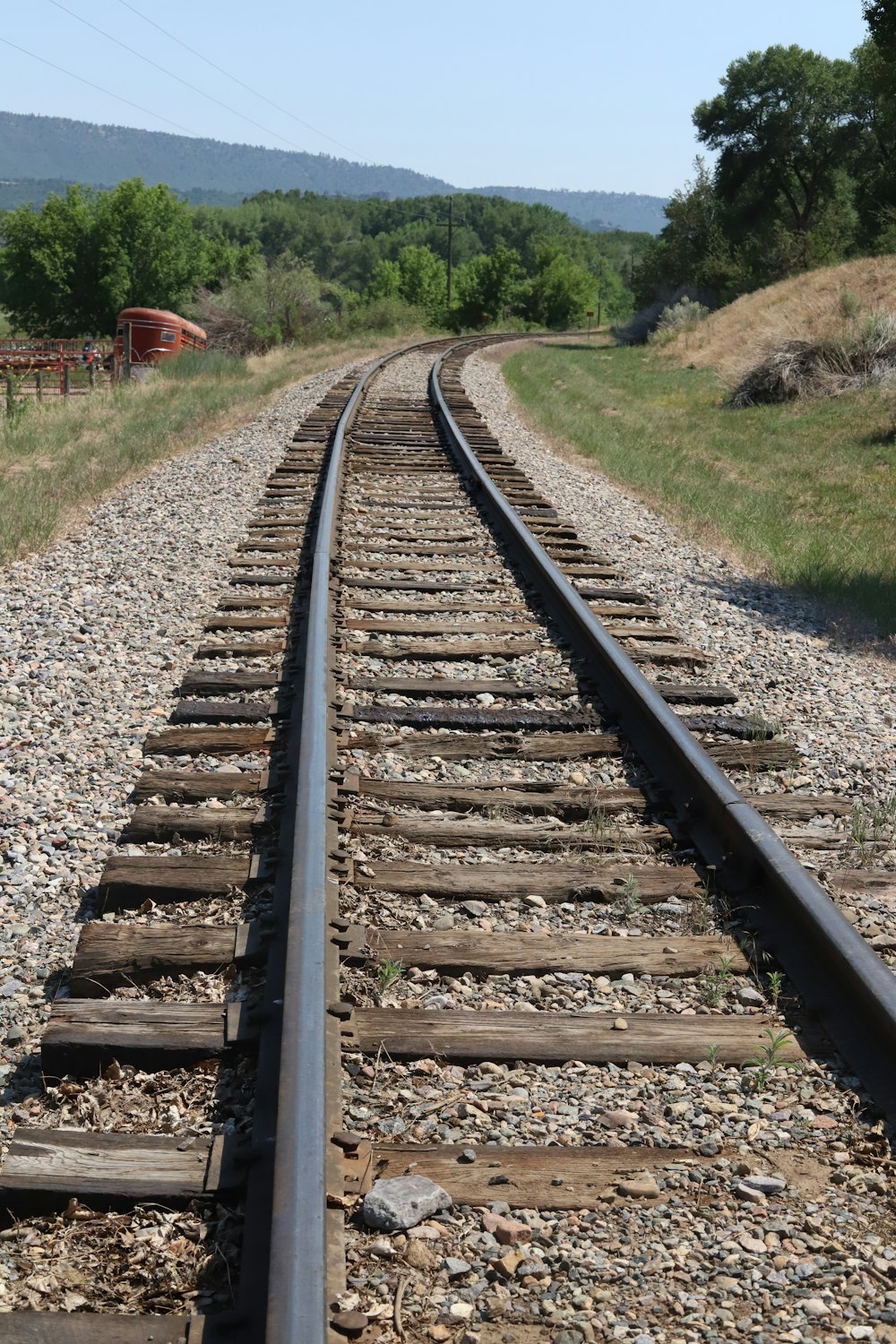 train rail tracks near green grass during daytime