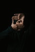 man in black leather jacket covering his face