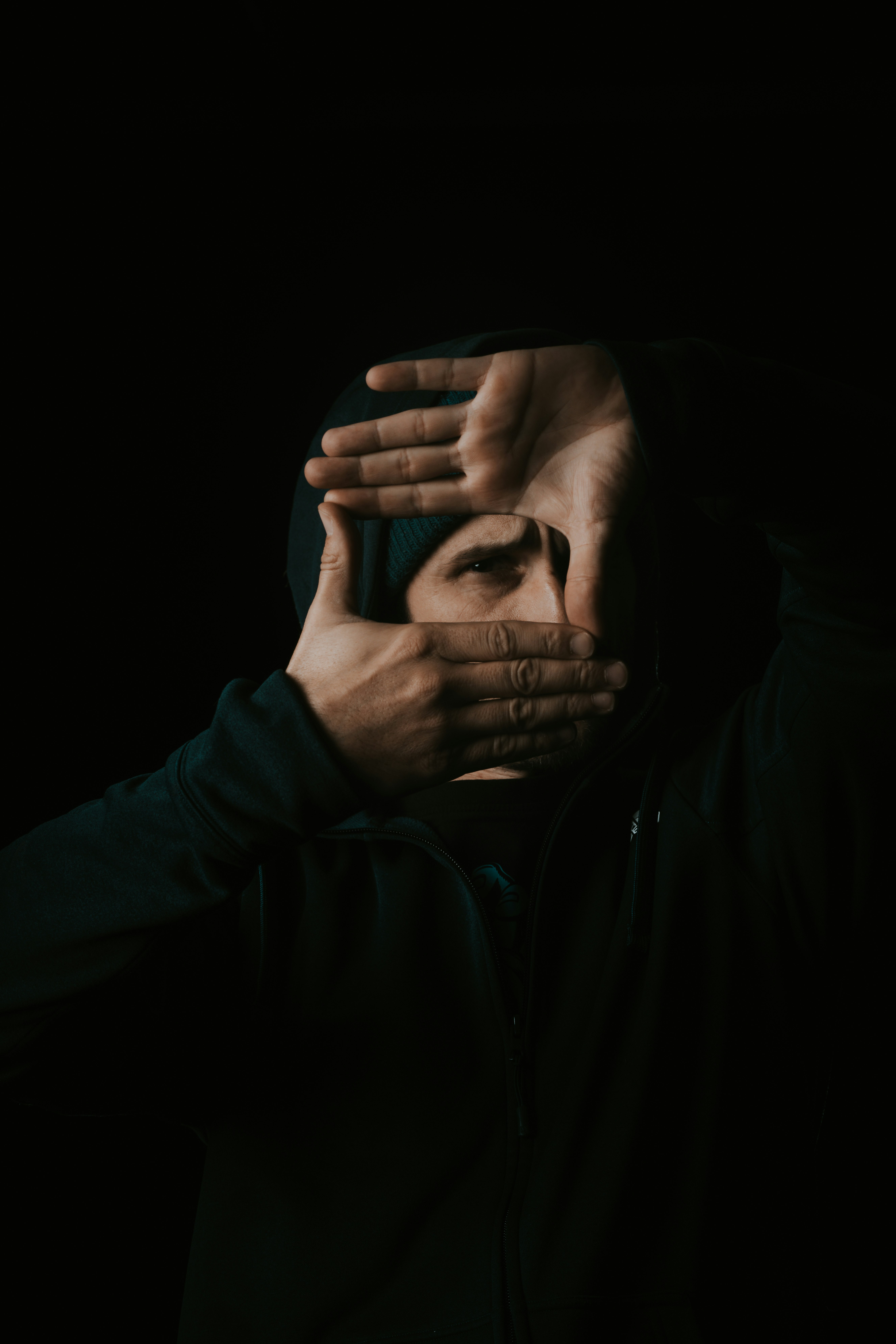 man in black leather jacket covering his face