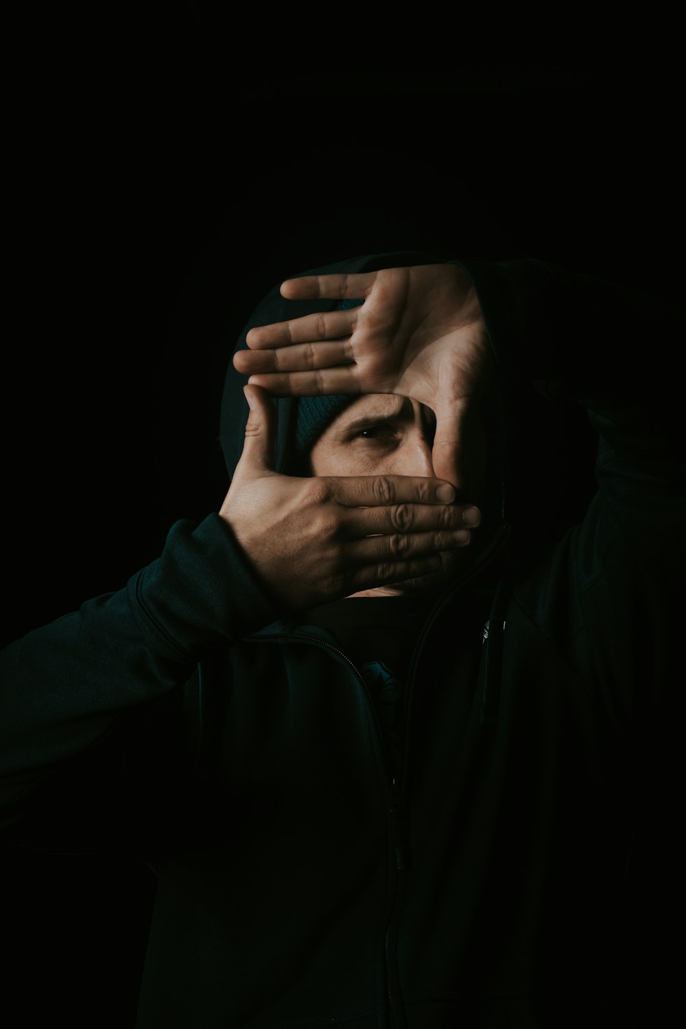 man in black leather jacket covering his face