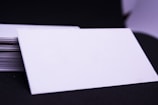 A stack of PVC Aadhaar cards on a wooden table.