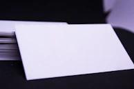 A stack of colorful calling cards fanned out on a wooden table.