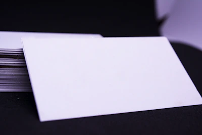 An elegant stack of gloss cards with smooth edges on a dark purple background.