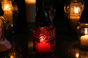 An arrangement of multicolored glass candle holders glowing softly