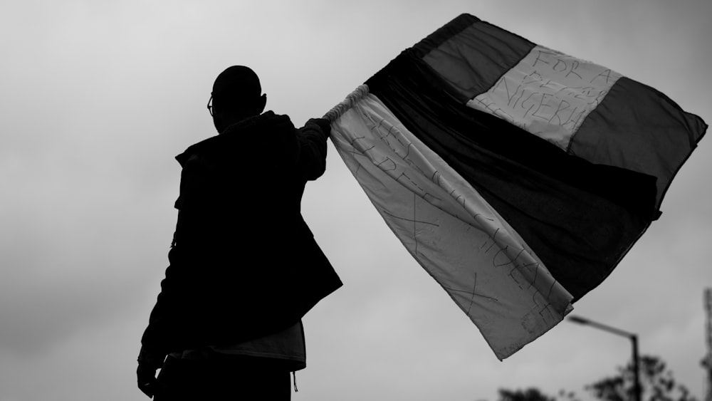 grayscale photo of man holding textile