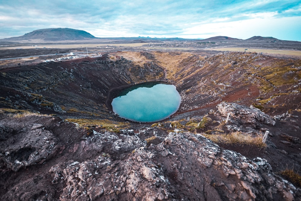 blue lake in the middle of brown and gray mountains