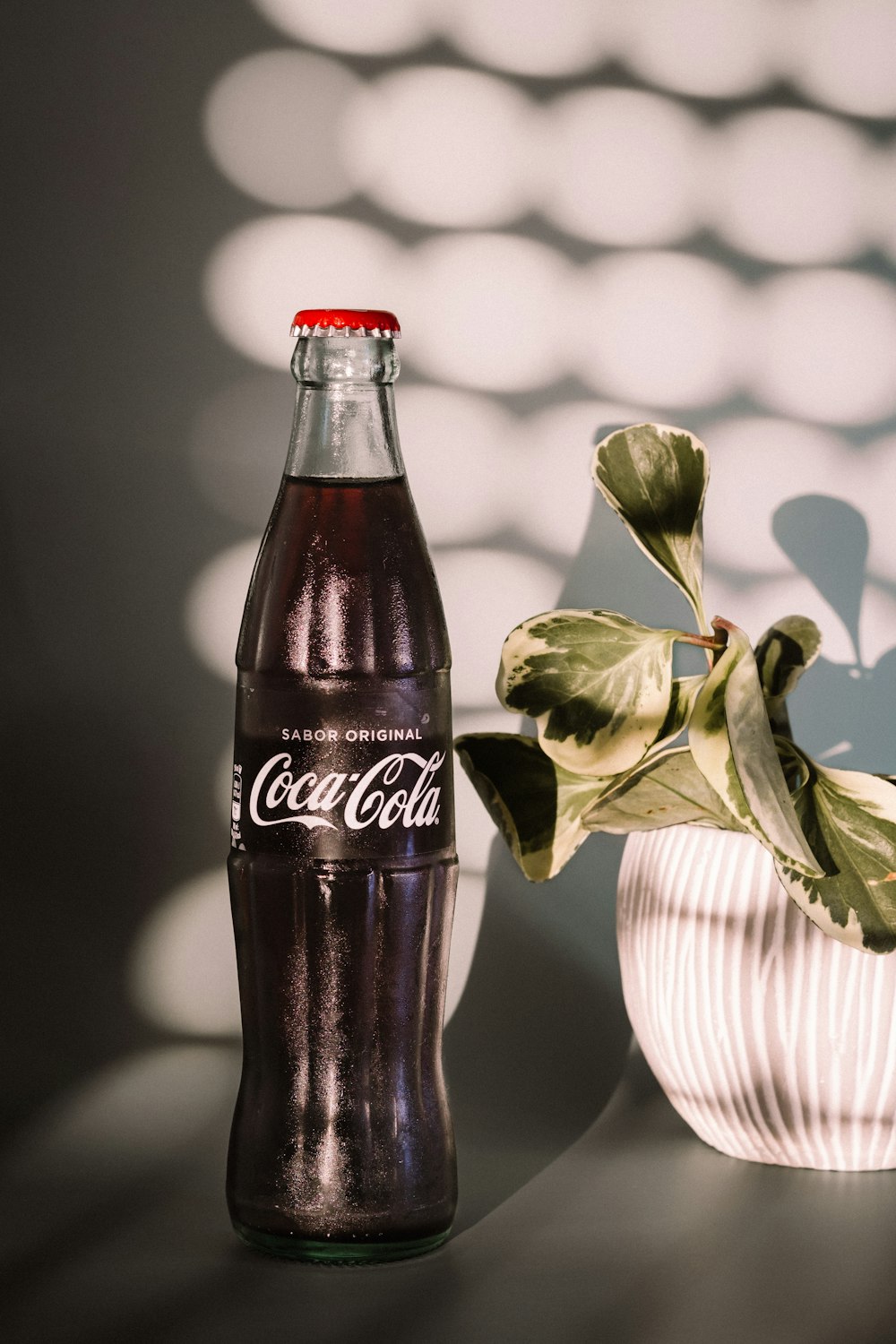 coca cola glass bottle with red liquid inside