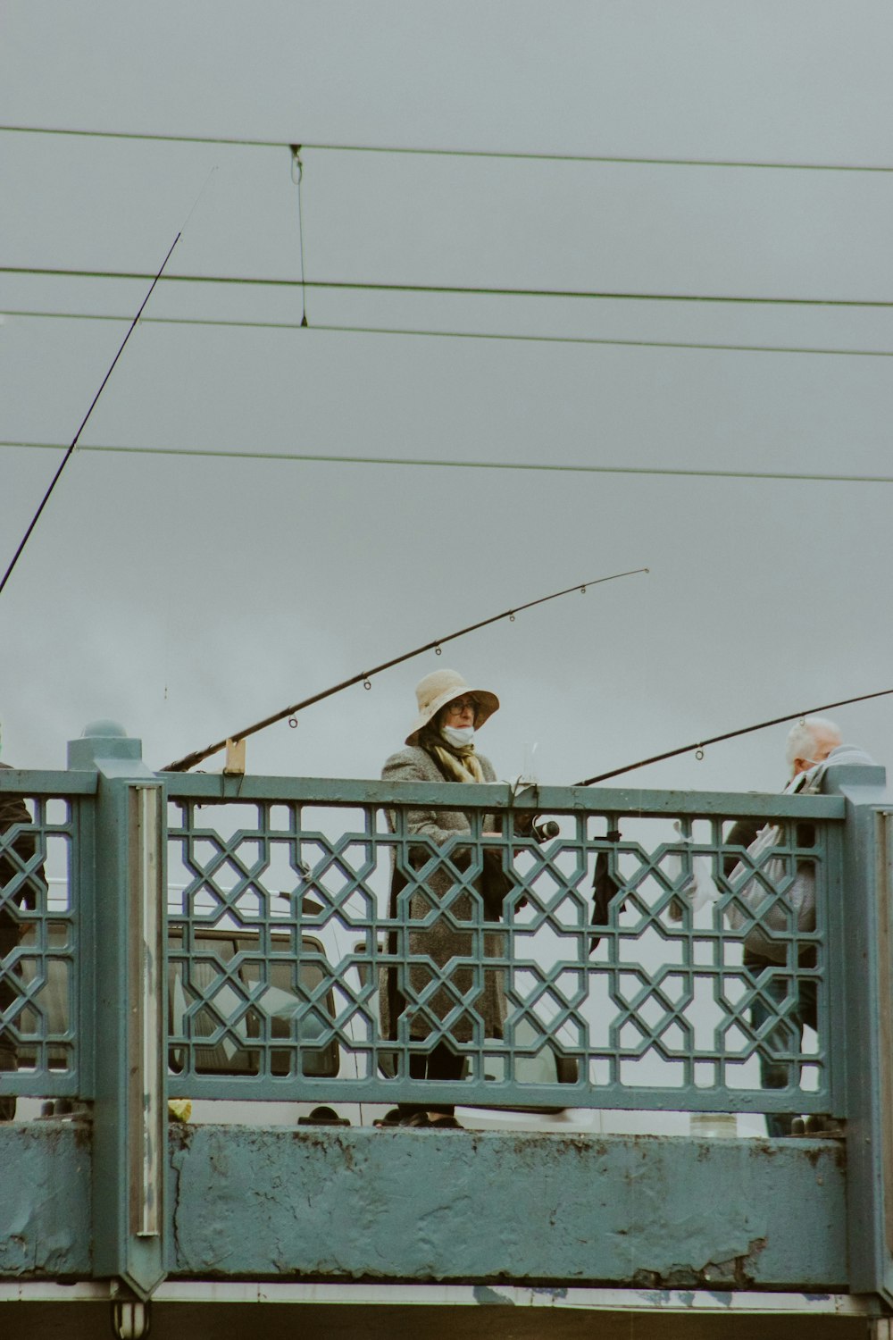 man in brown jacket and brown hat standing on white building during daytime