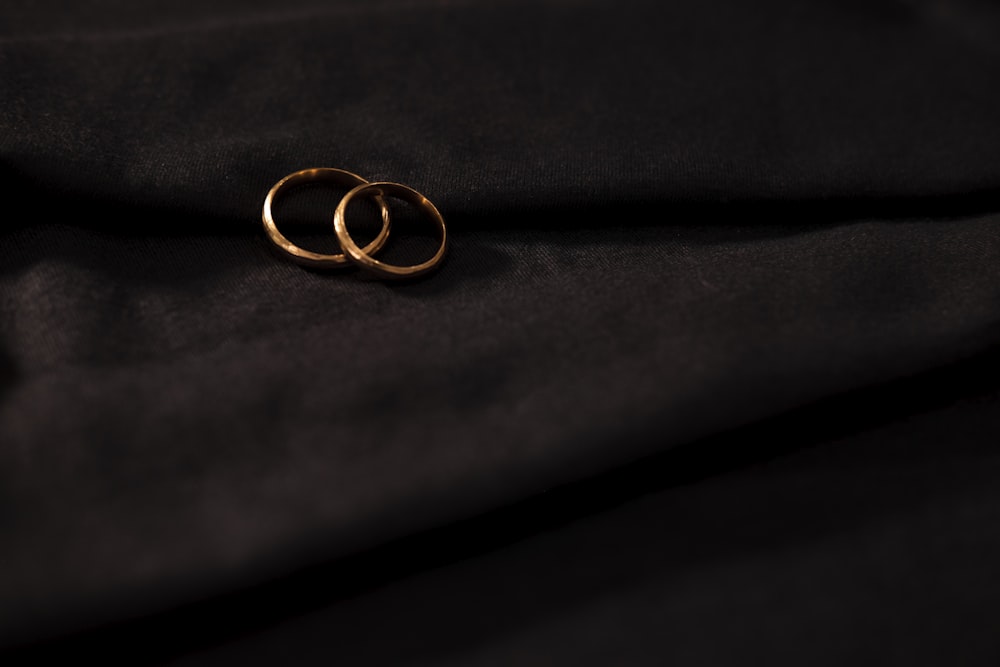 Alianza de boda dorada sobre textil negro