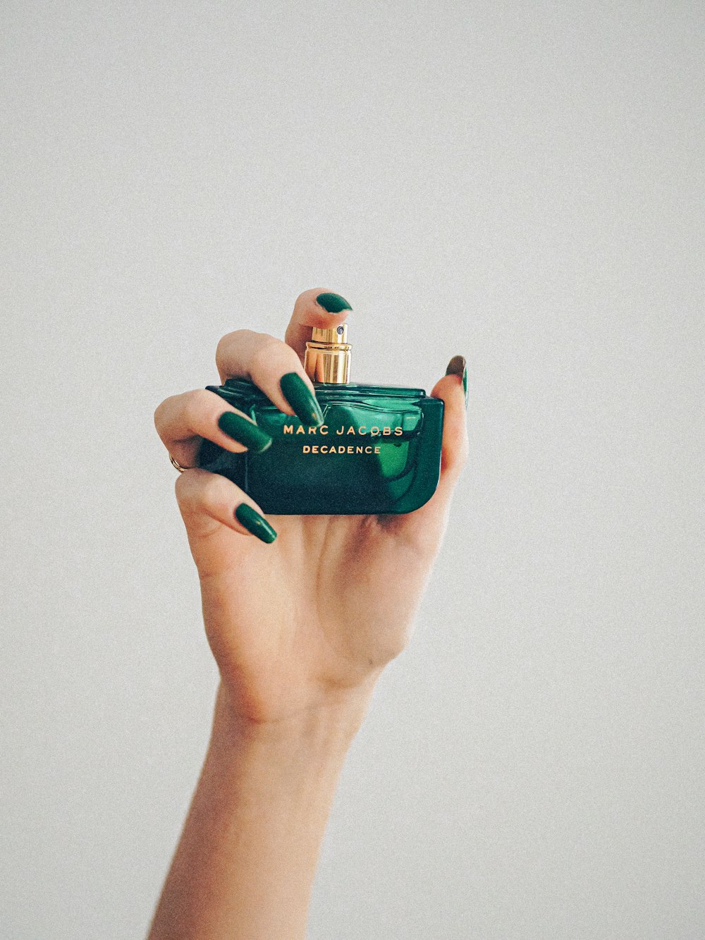 person holding blue glass bottle