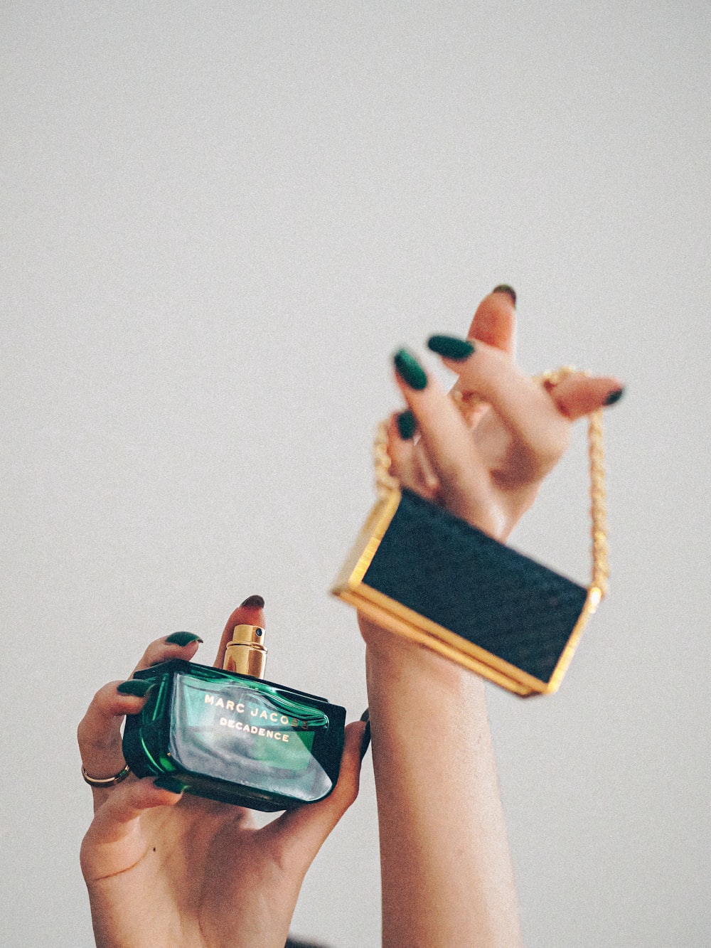 person holding green glass bottle