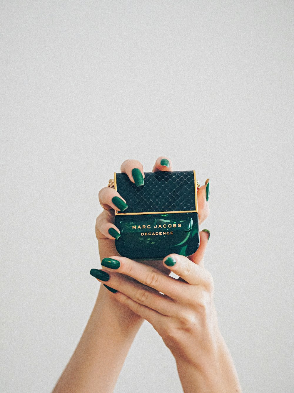 person holding black and green box
