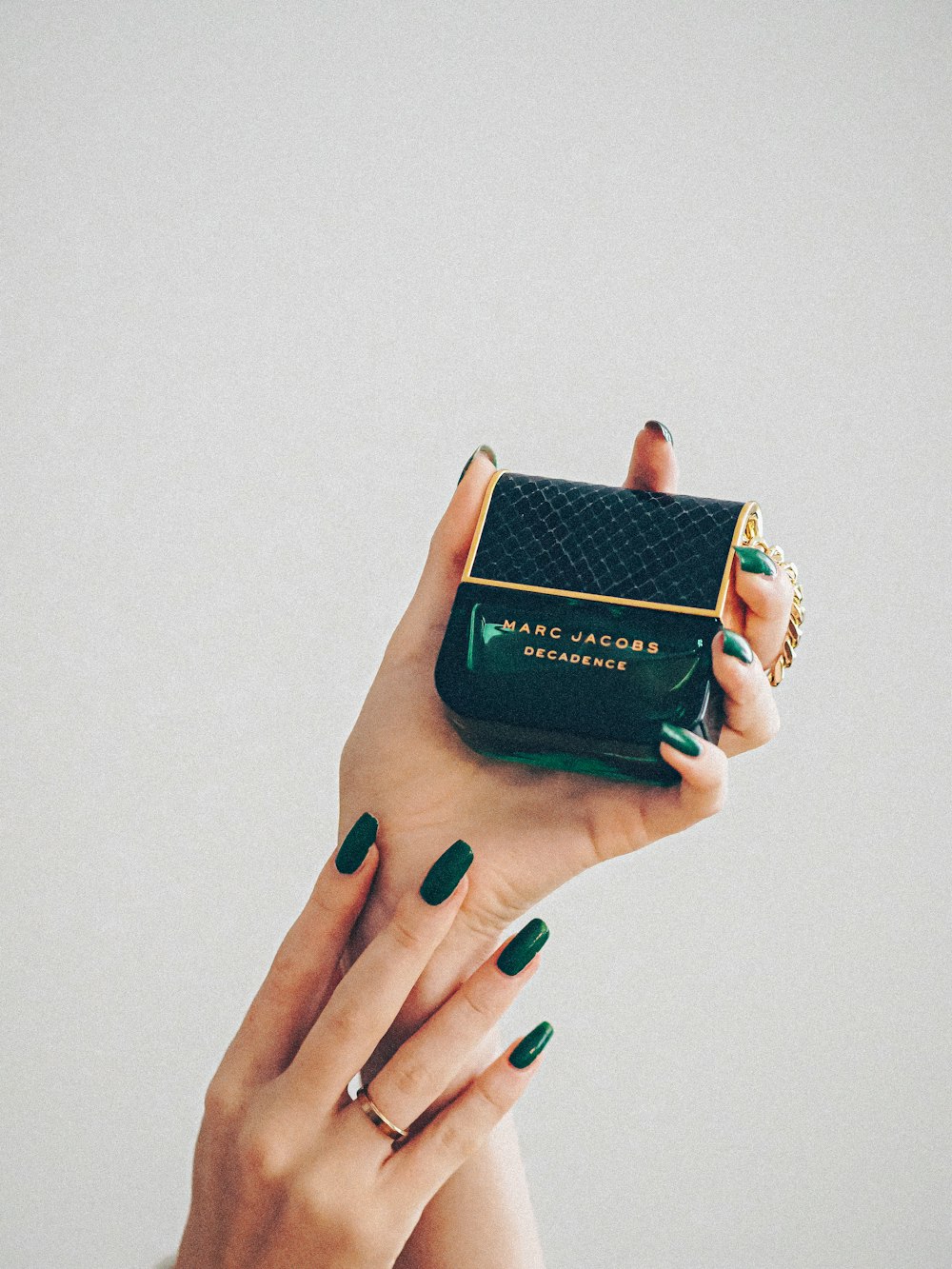 a woman's hand holding a green purse