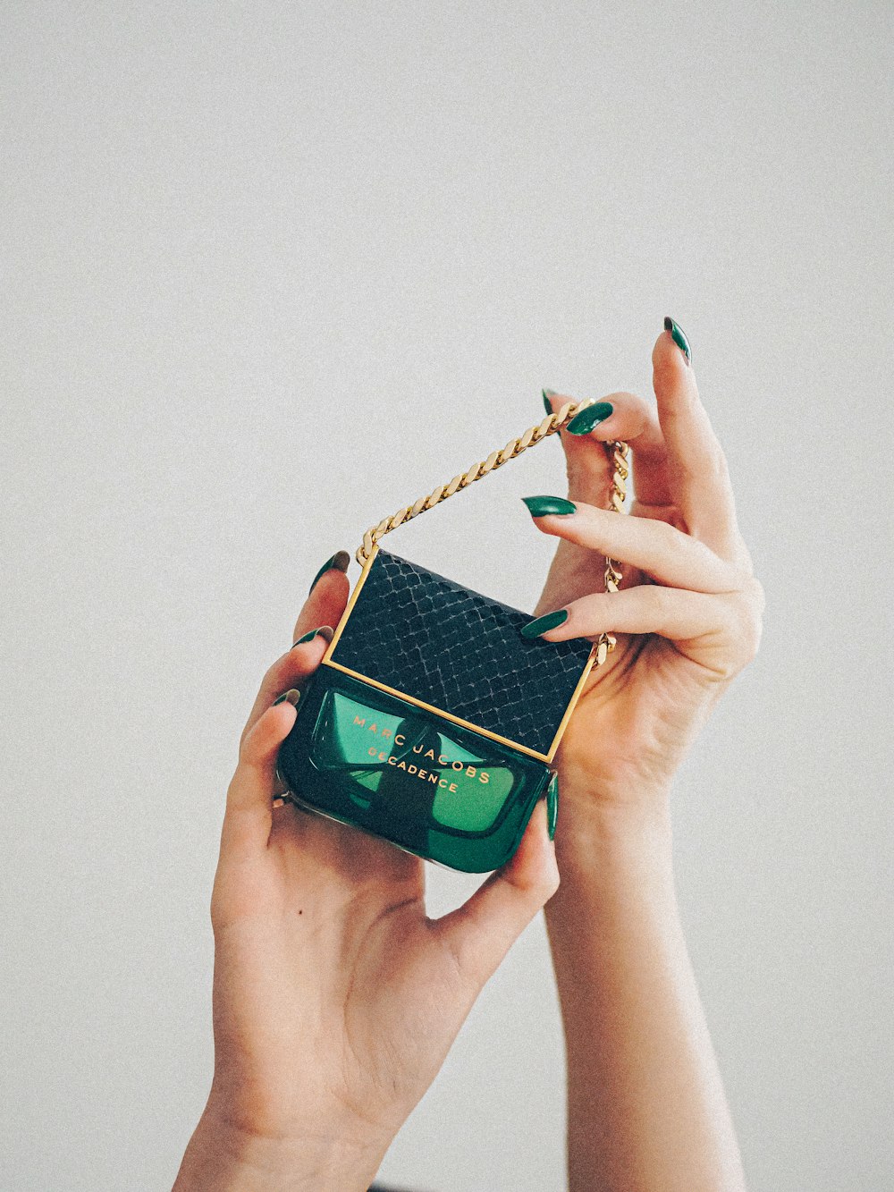 person holding green and black portable speaker