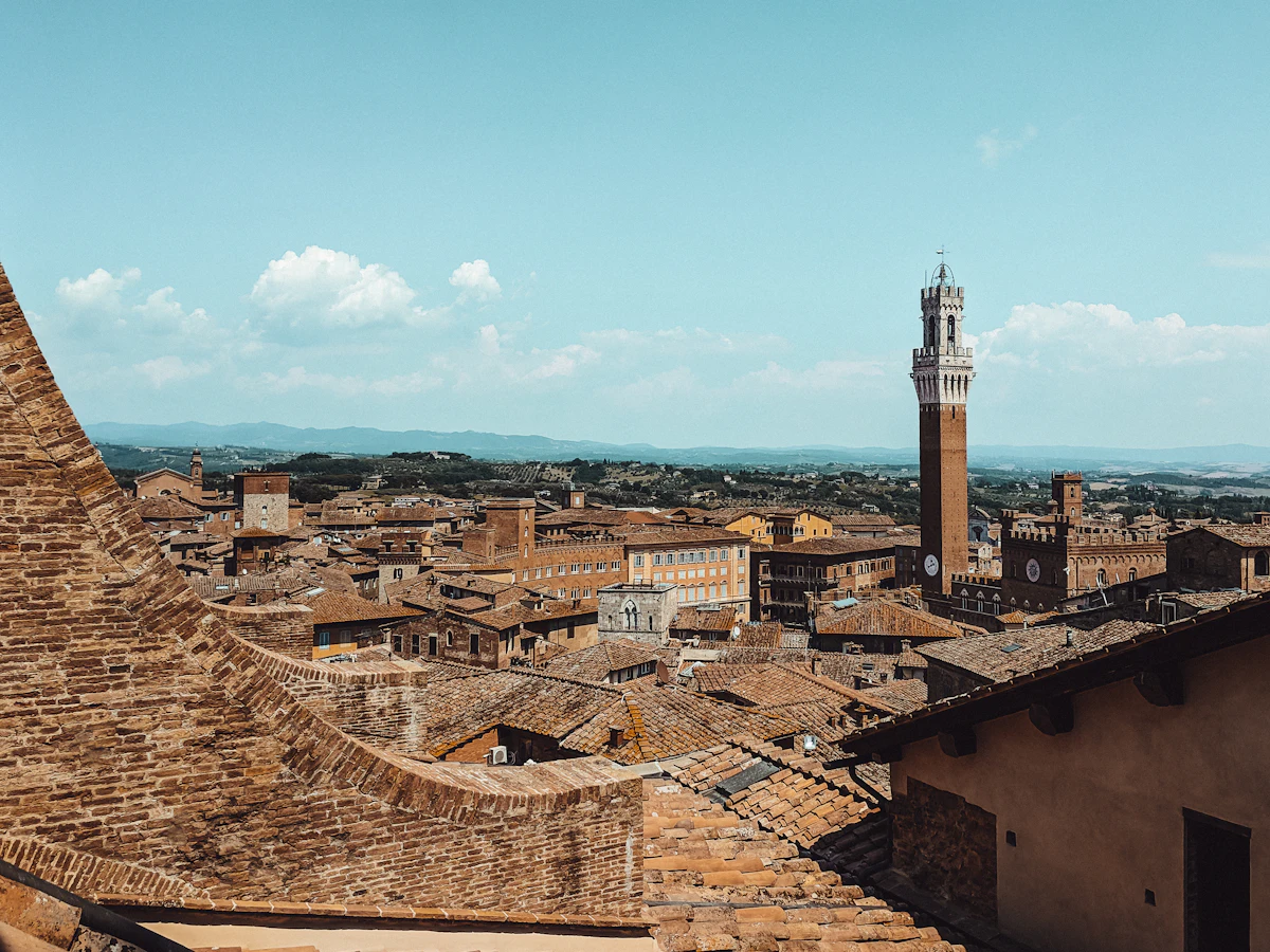 The rooftops of Siena from above, with the Torre del Mangia and hills beyond