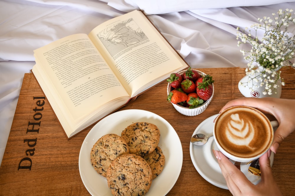 cookies on white ceramic plate beside white ceramic mug with saucer