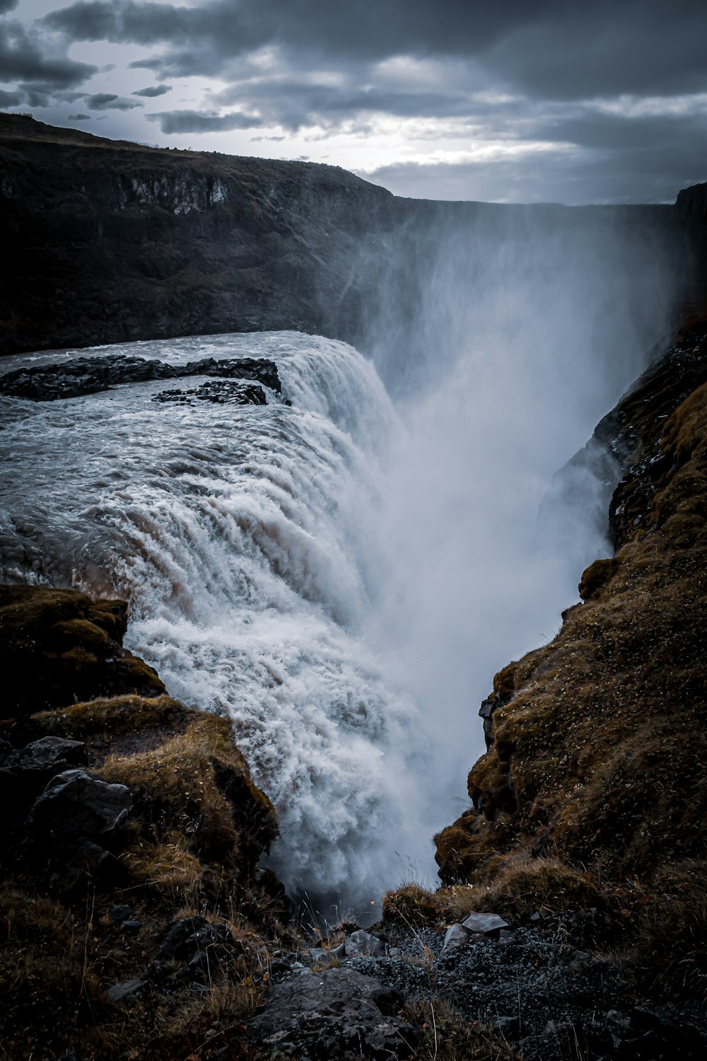 water falls on brown rocky mountain