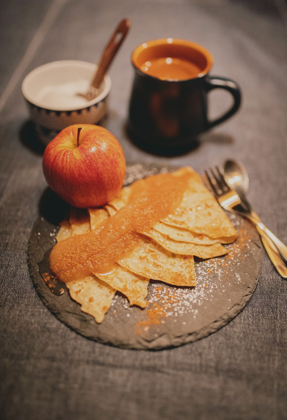 red apple fruit beside stainless steel fork and knife