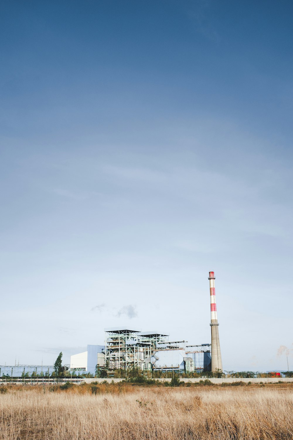 white and black factory under blue sky during daytime