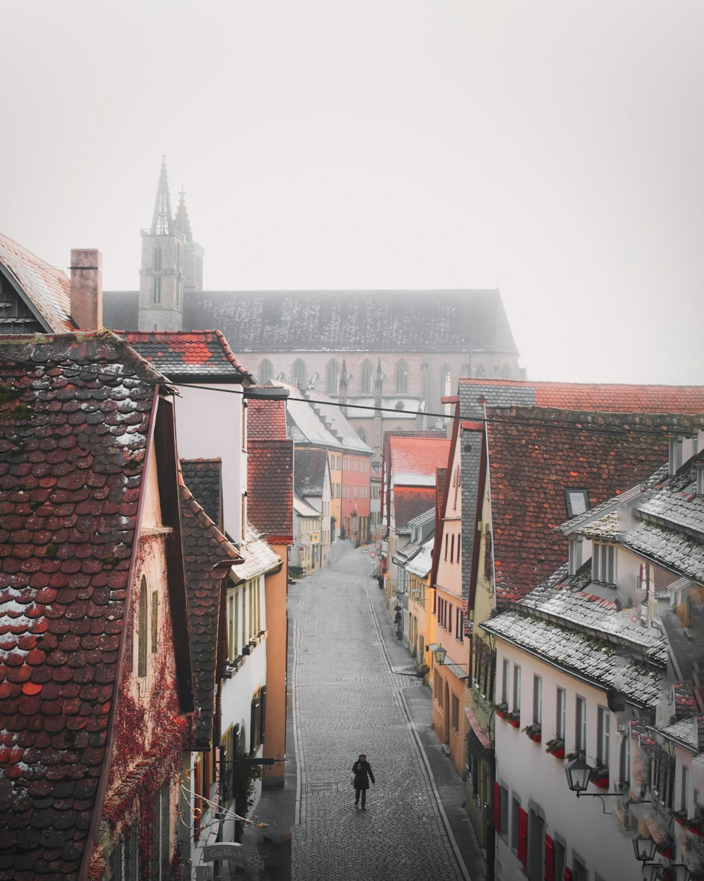 people walking on street between houses during daytime