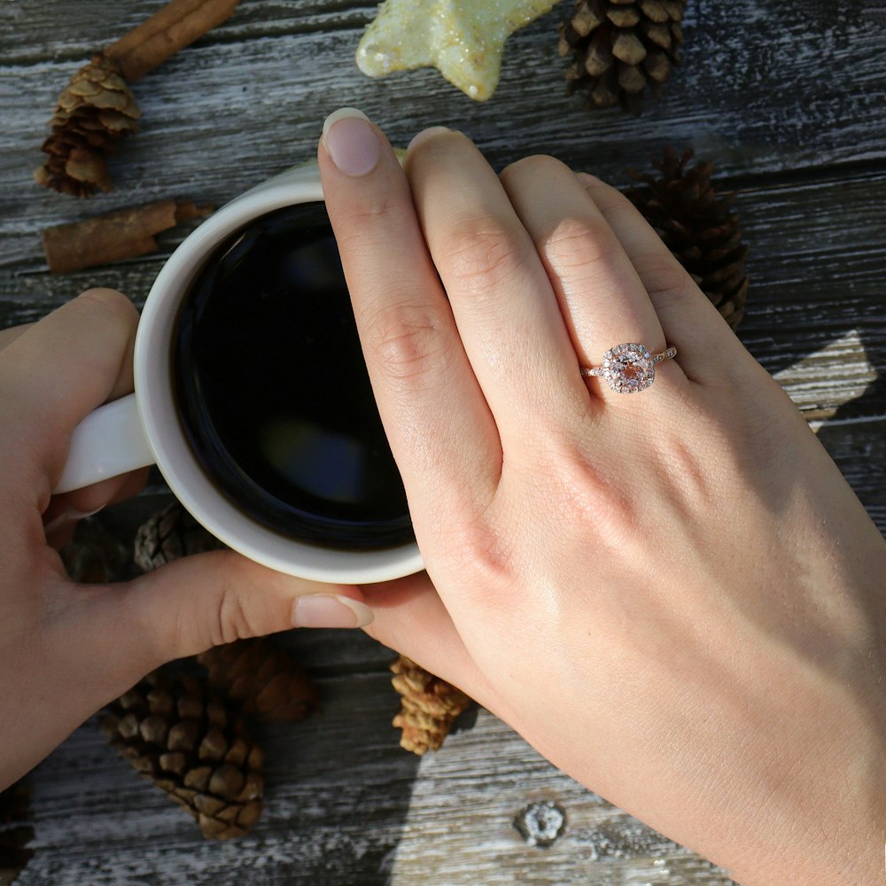 person holding white ceramic mug with coffee