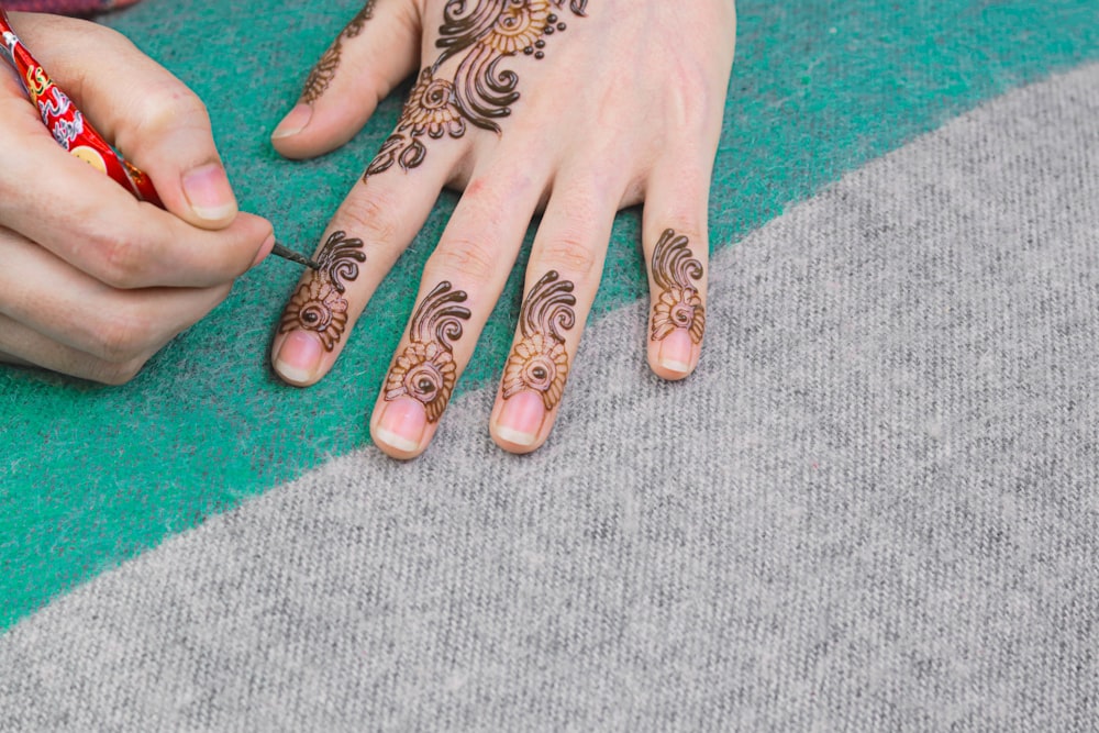 person with black and white floral tattoo on left hand