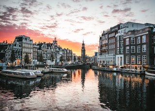 white boat on river between buildings during daytime