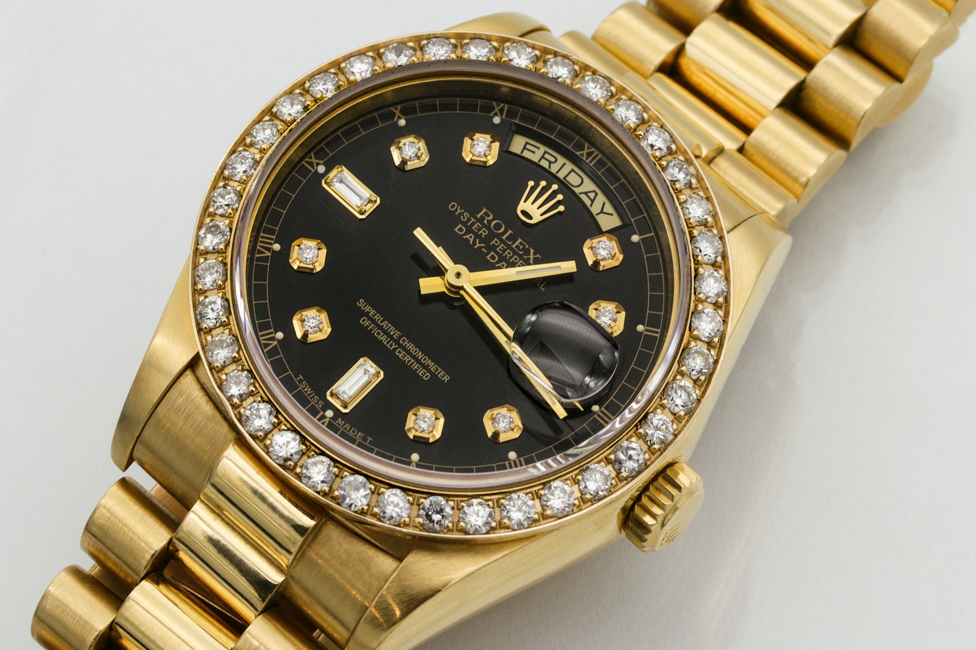 Mens 18K yellow gold president date/just Rolex with diamond bezel and diamond markers on black dial. 
