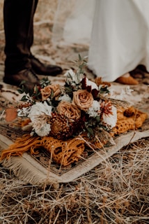 brown and white flowers on brown dried leaves