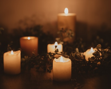white pillar candle on brown wooden table