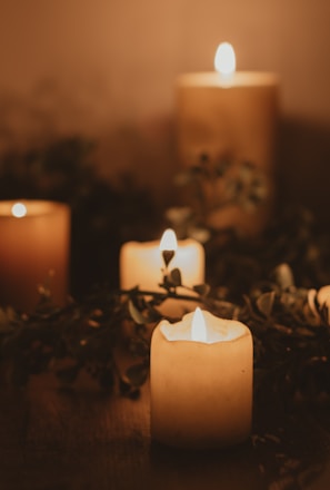 white pillar candle on brown wooden table