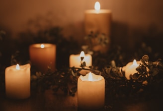 white pillar candle on brown wooden table