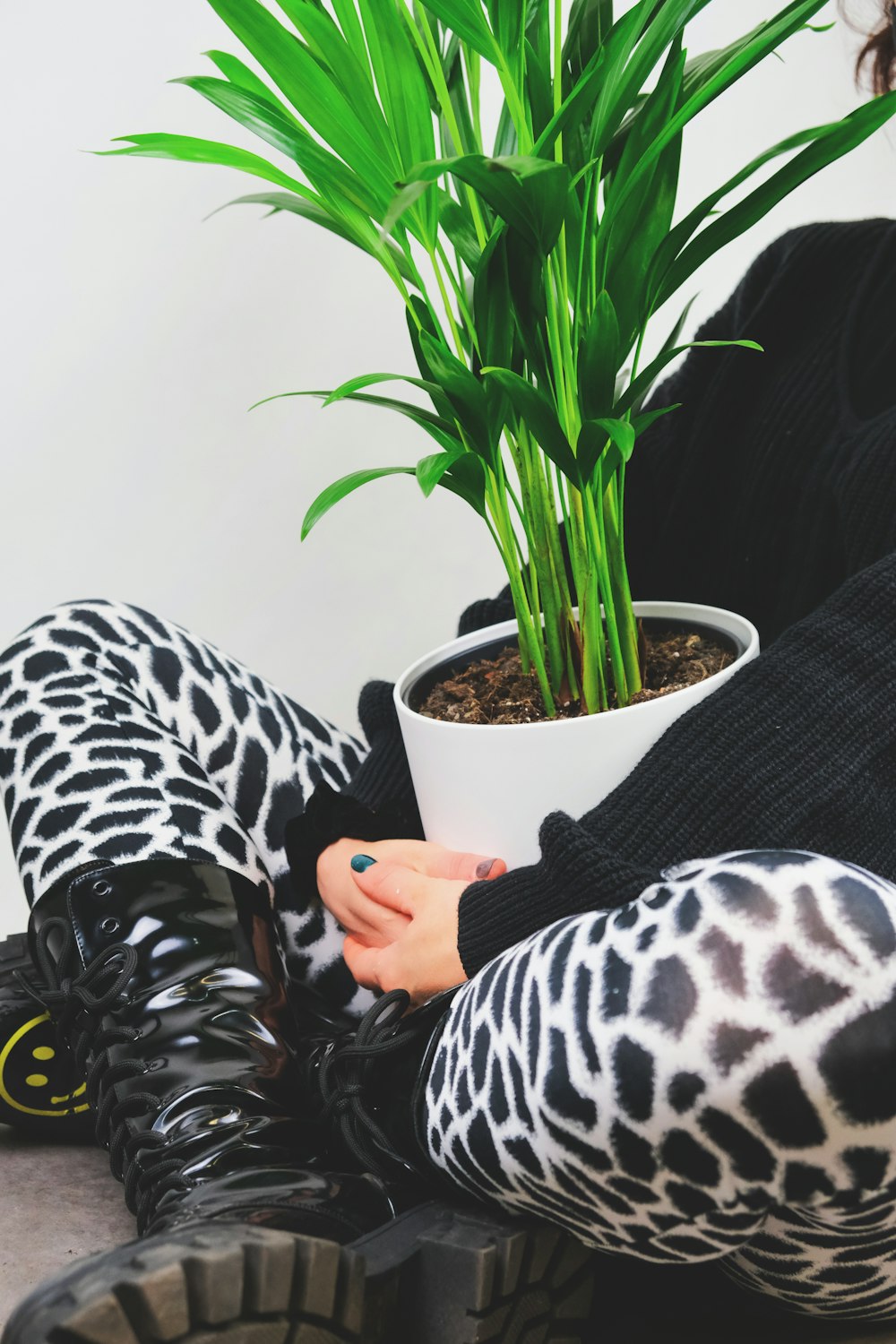 person in black and white zebra print pants sitting on black couch