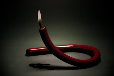 red lighted candle on white surface
