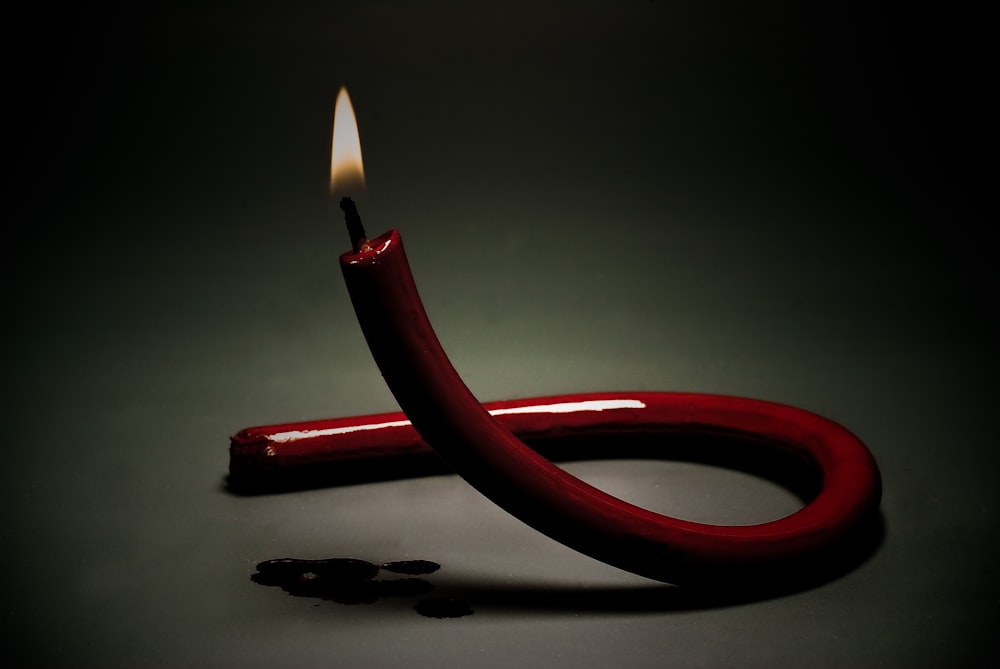 red lighted candle on white surface